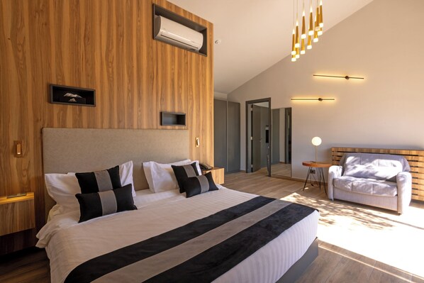 Un dormitorio moderno con una cama grande, una pared de acento de madera y una lámpara en el techo.