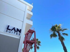 A building with a sign reading "LAN SUITES" and a red staircase. - LAN Suites (Lepe)