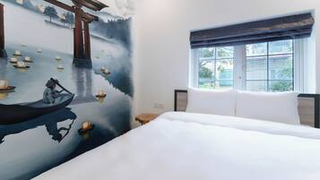 A hotel room with a large bed, a window with a view, and a mural of a serene water scene with boats.