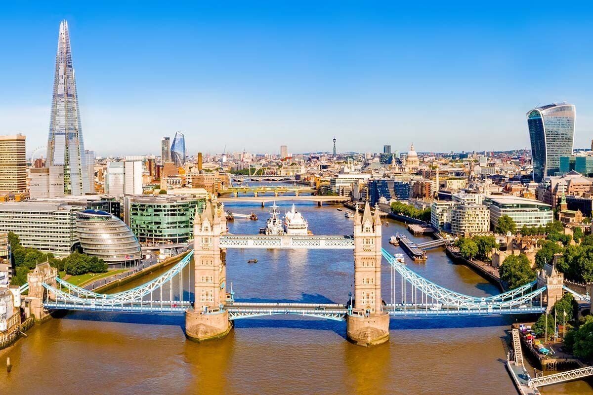 Un paisaje urbano con un puente destacado, edificios modernos y un río.