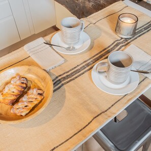A breakfast setup with pastries, two cups of coffee, and a candle on a table. - Plinio 10 in Como With 2 Bedrooms and 2 Bathrooms (Como)