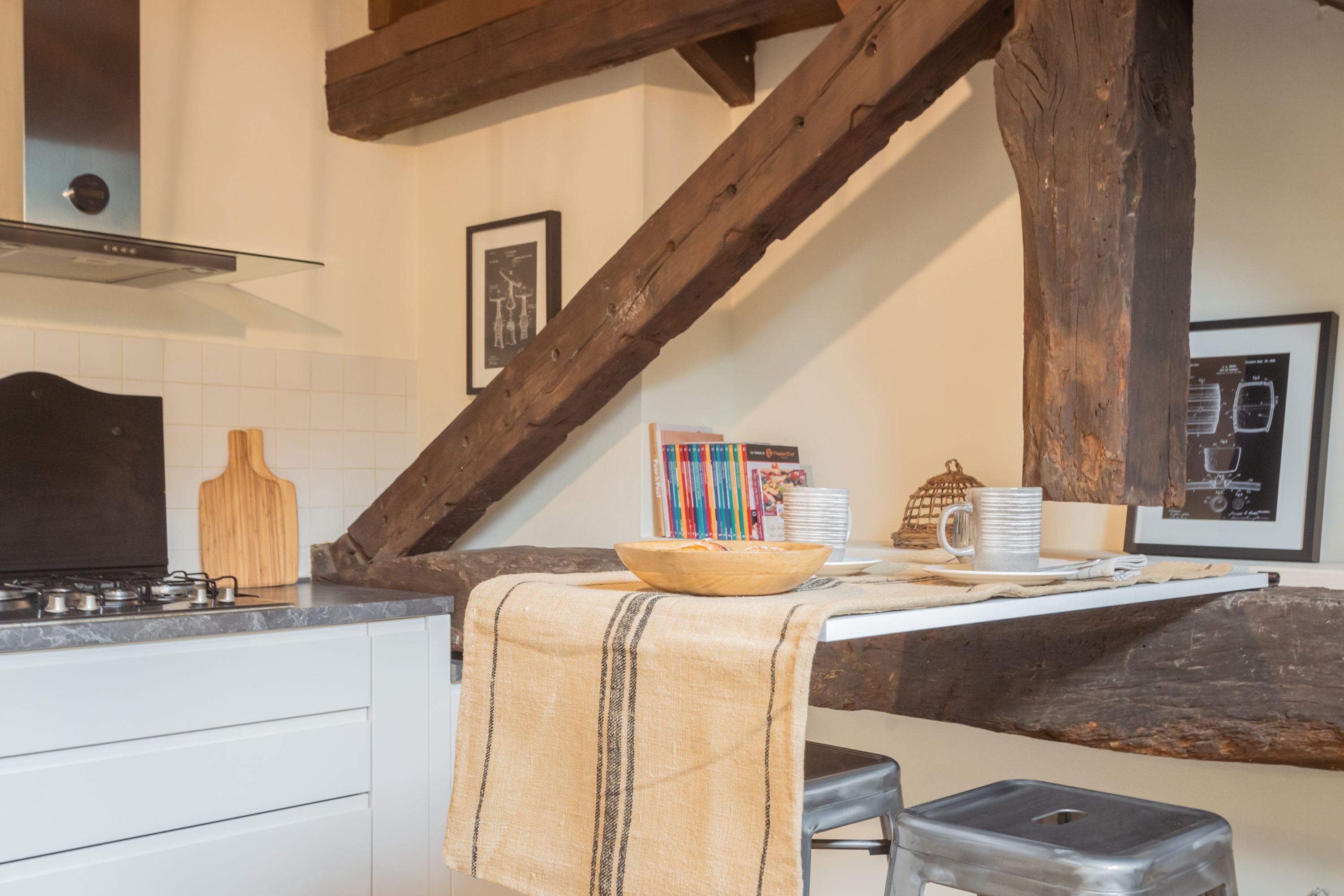Una cocina con una mesa de madera, un bol y una cafetera.