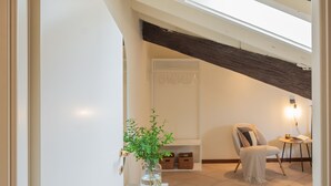 A modern loft bedroom with a skylight, a cozy seating area, and a minimalist decor. - Plinio 10 in Como With 2 Bedrooms and 2 Bathrooms (Como)