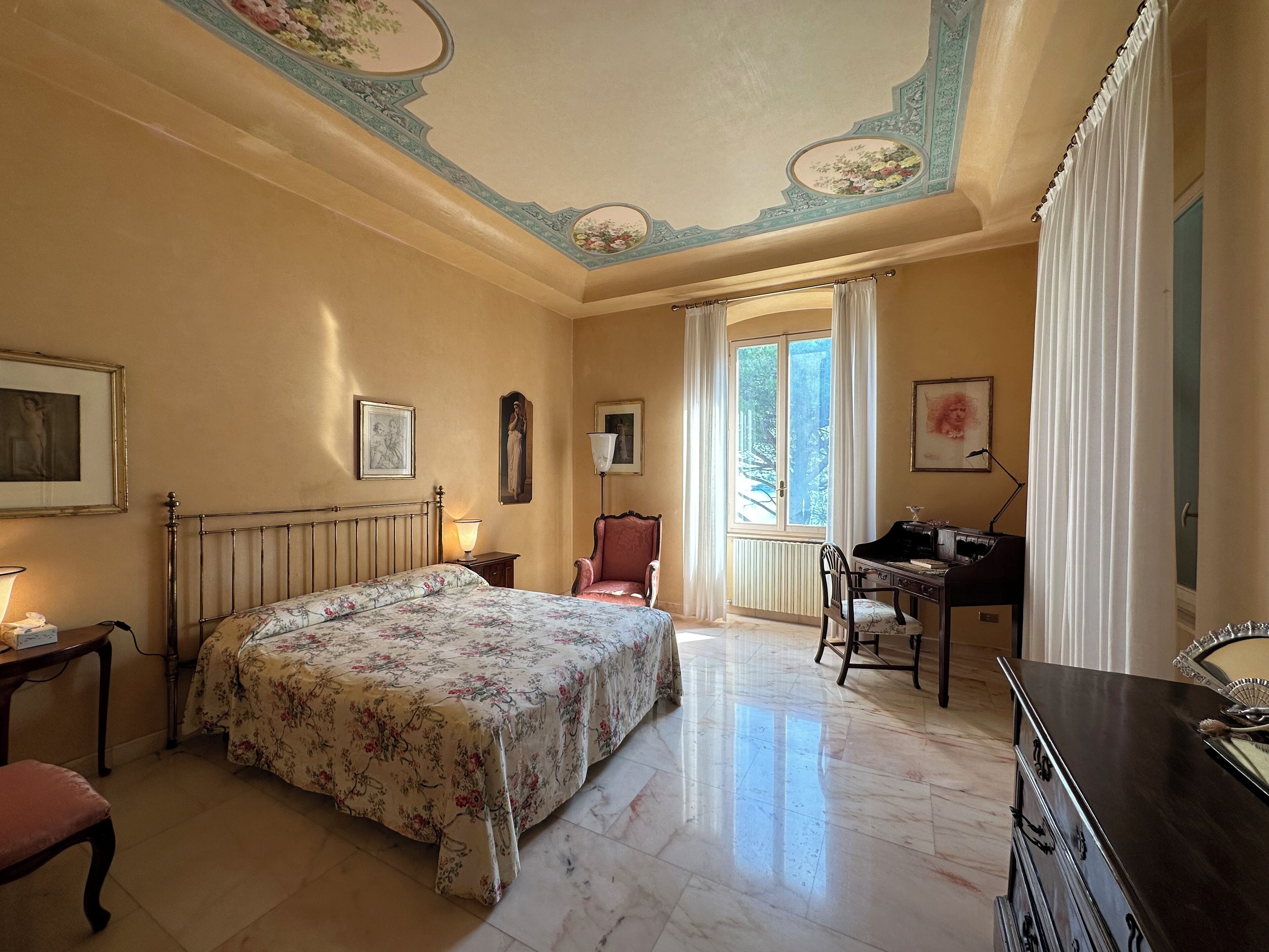 Um quarto com uma cama, escrivaninha, cadeira e cômoda.