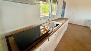 Een moderne keuken met een inbouwoven, een spoelbak en een raam.