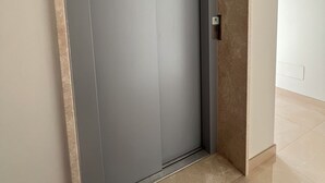 A modern elevator with a metallic finish, located in a hallway with a tiled floor and a plain wall. - Novimo Comfort Apartment with elevator and secure private parking (Terrasini)