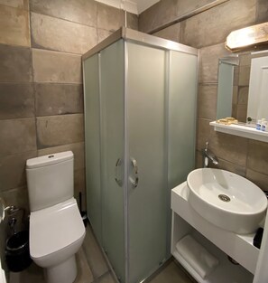 Habitación estándar doble, vistas parciales al mar | Baño | Ducha, cabezal de ducha tipo lluvia, secador de pelo y toallas