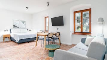 A modern room with a bed, a dining table, and a sofa.