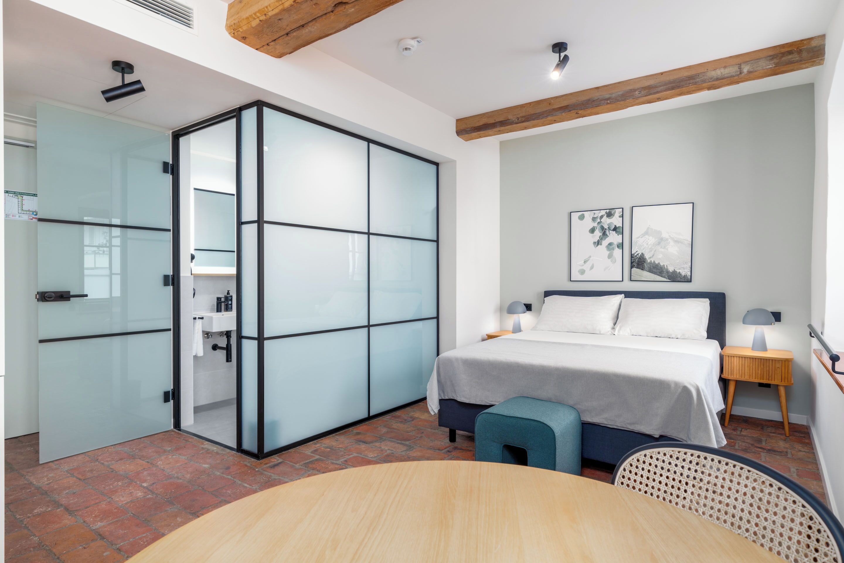 A modern bedroom with a bed, bedside tables, a desk, and a chair.