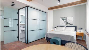 A modern bedroom with a bed, bedside tables, a desk, and a chair.