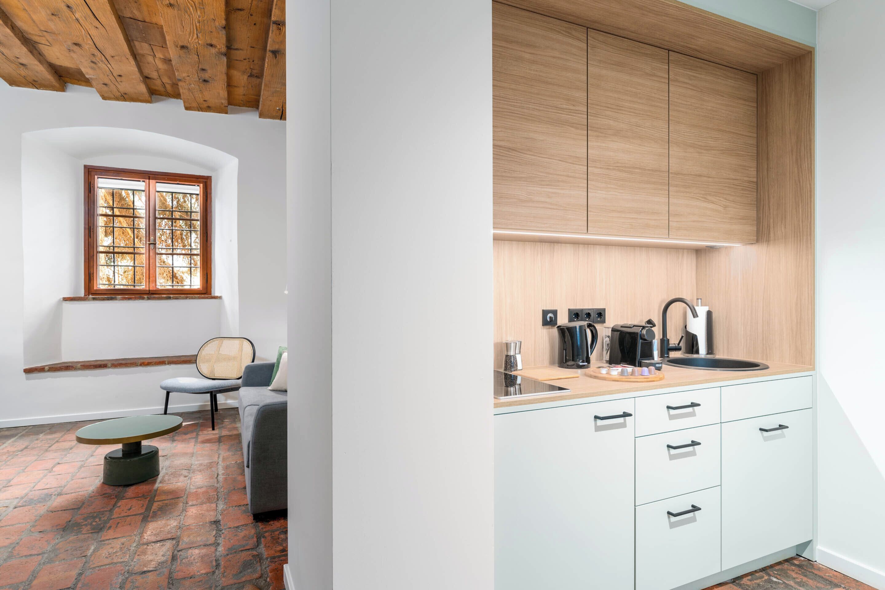 A modern kitchen with white cabinets, a wooden countertop, and a built-in sink.