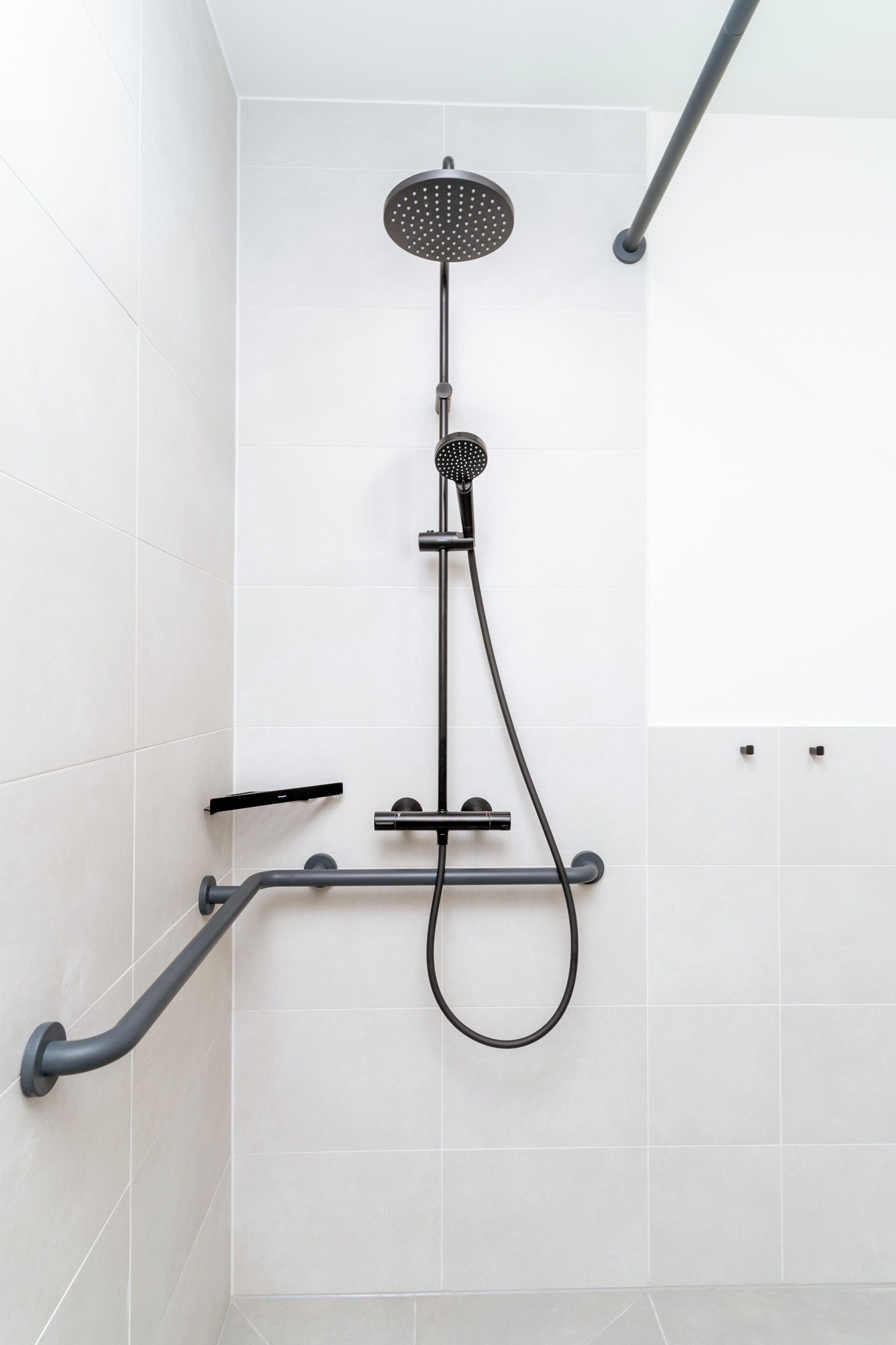 Un bagno moderno con una doccetta, un soffione a mano e un rubinetto estraibile.