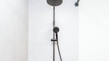 Un bagno moderno con una doccetta, un soffione a mano e un rubinetto estraibile.
