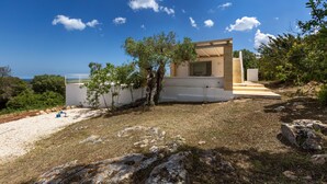 Une maison moderne à l’extérieur blanc, dotée d’un petit porche et offrant une vue sur la mer.