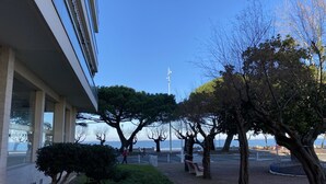 A building with a large glass facade, a landscaped area with trees and shrubs, and a view of the sea. - Central Arcachon Apartment: Beach & Shops on Foot (Arcachon)