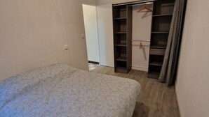 A bedroom with a bed, a wardrobe, and a closet.