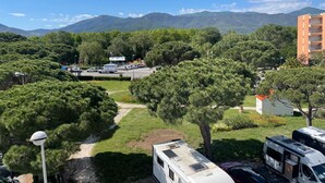 Ein Campingplatz mit Wohnmobilen, einem Parkplatz und einem Berg im Hintergrund.