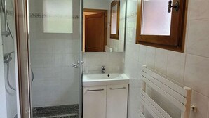 A bathroom with a glass shower enclosure, a sink, and a mirror. - Spacious T4 with garage and parking in Grand-Bornand - 6 pers (Le Grand-Bornand)