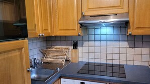 A kitchen with wooden cabinets, a Bosch dishwasher, and a tiled backsplash. - Spacious T4 with garage and parking in Grand-Bornand - 6 pers (Le Grand-Bornand)