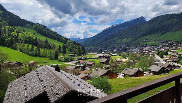 A village with traditional wooden houses, a mountain backdrop, and a clear sky. - Spacious T4 with garage and parking in Grand-Bornand - 6 pers (Le Grand-Bornand)