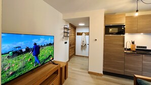 A modern kitchen with wooden cabinets and a built-in oven. - Charming apartment in Les Gets, 2 bedrooms, Wi-Fi, parking included (Les Gets)