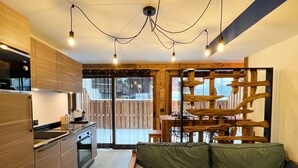 A modern kitchen with wooden cabinets, a Bosch refrigerator, and a dining area with a wooden table and chairs. - Charming apartment in Les Gets, 2 bedrooms, Wi-Fi, parking included (Les Gets)