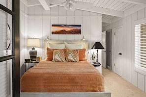A bedroom with a bed, a nightstand, a lamp, a painting, and a ceiling fan. - Charming Ranch-Style Home with Hot Tub, EV Charger (Sedona)