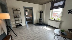 Ein modernes Wohnzimmer mit Kamin, Esstisch und Blick ins Freie.