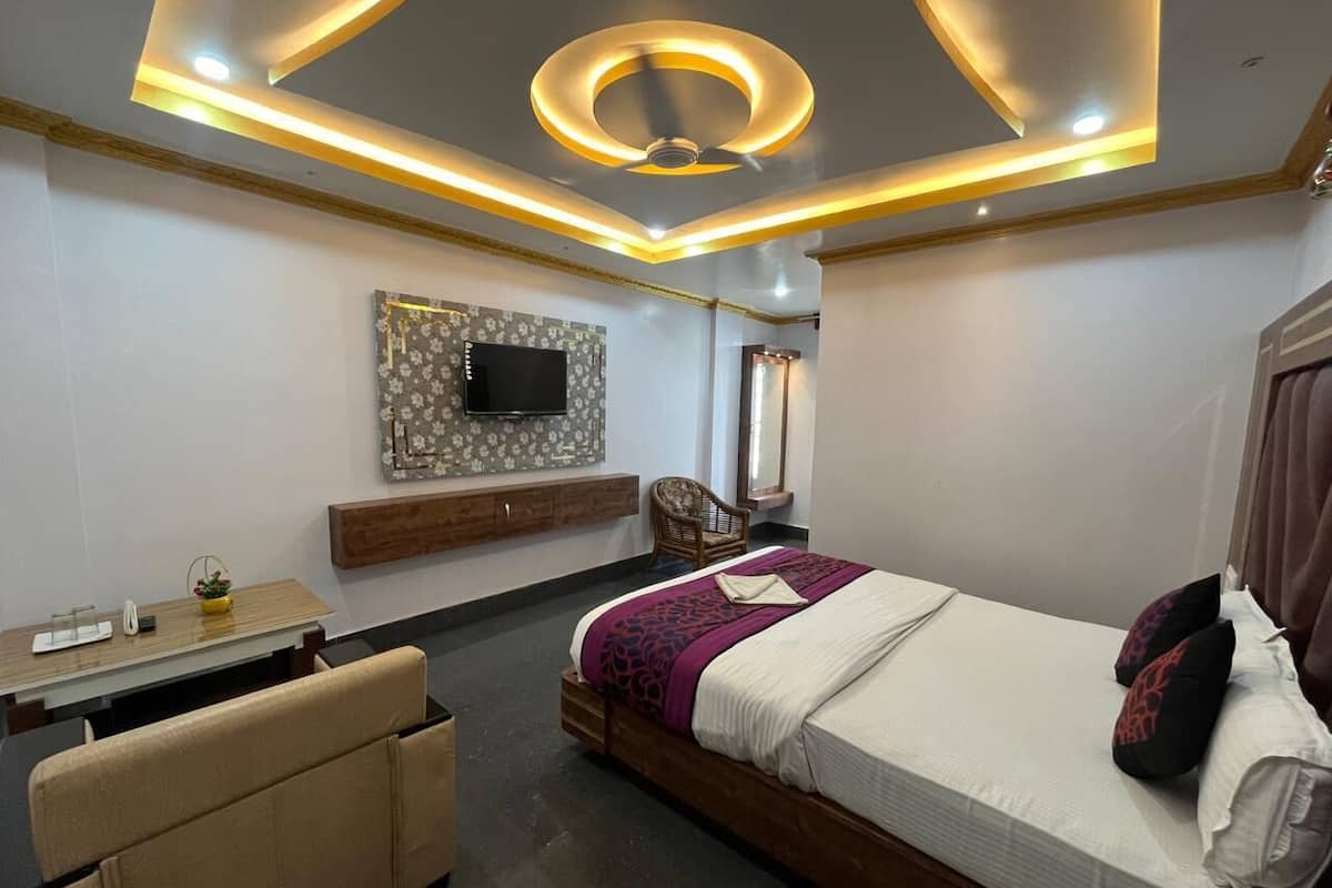 A modern bedroom with a bed, a TV mounted on the wall, a desk, and a chair.