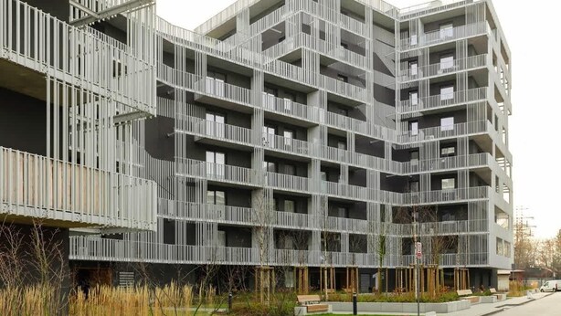 A modern multi-story residential building with balconies and a landscaped courtyard. - Spacious Apartment in Wola | Parking | Balcony (Warszawa)