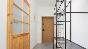 A hallway with a wooden door and metal shelving units.
