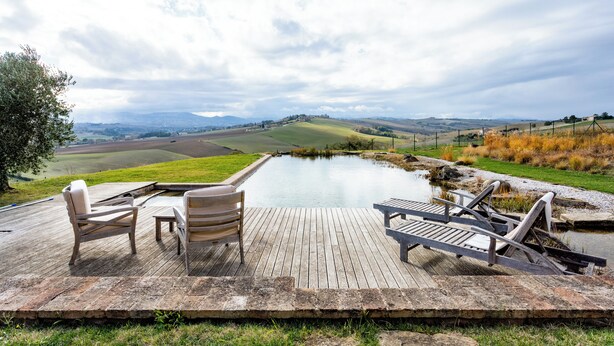 A wooden deck with outdoor seating overlooking a pond and distant hills. - Elegant typical farmhouse with pool large wooded courtyard 10 minutes from Jesi (Marche)