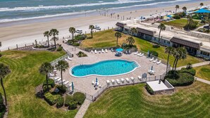 Una località turistica con piscina, accesso alla spiaggia e vista sull'oceano.