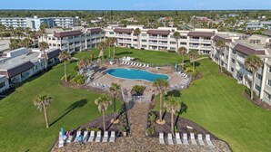 A resort with a central pool, multiple balconies, and a well-maintained lawn. - Chateau by the Sea 12D Ocean Breeze & Views! (New Smyrna Beach)