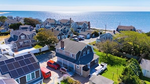 A coastal residential area with houses, a swimming pool, and a red van parked in front. - Recently updated home sleeping 10, steps to the beach! (Harwich Port)