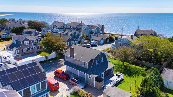 A coastal residential area with houses, a swimming pool, and a red van parked in front.