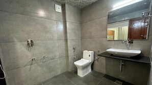 Un baño moderno con inodoro, lavamanos y espejo.