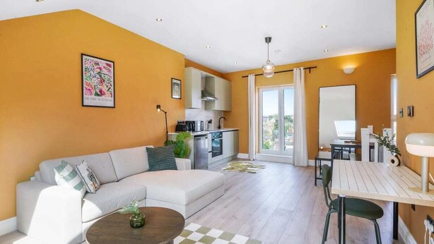 Un salon moderne comprenant un canapé, une table à manger et un coin cuisine.