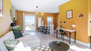 Un salon moderne comprenant un canapé, une table basse et un coin repas avec des chaises et une table.