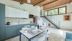 Une cuisine moderne avec un coin repas, un escalier et une grande fenêtre.