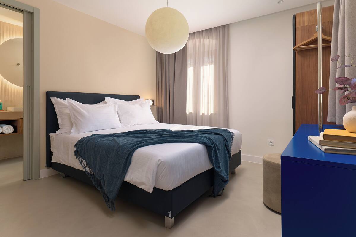 Un dormitorio moderno con cama, mesita de noche y armario.