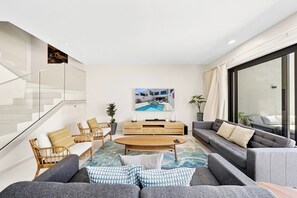 A modern living room with a sofa set, a coffee table, and a television.