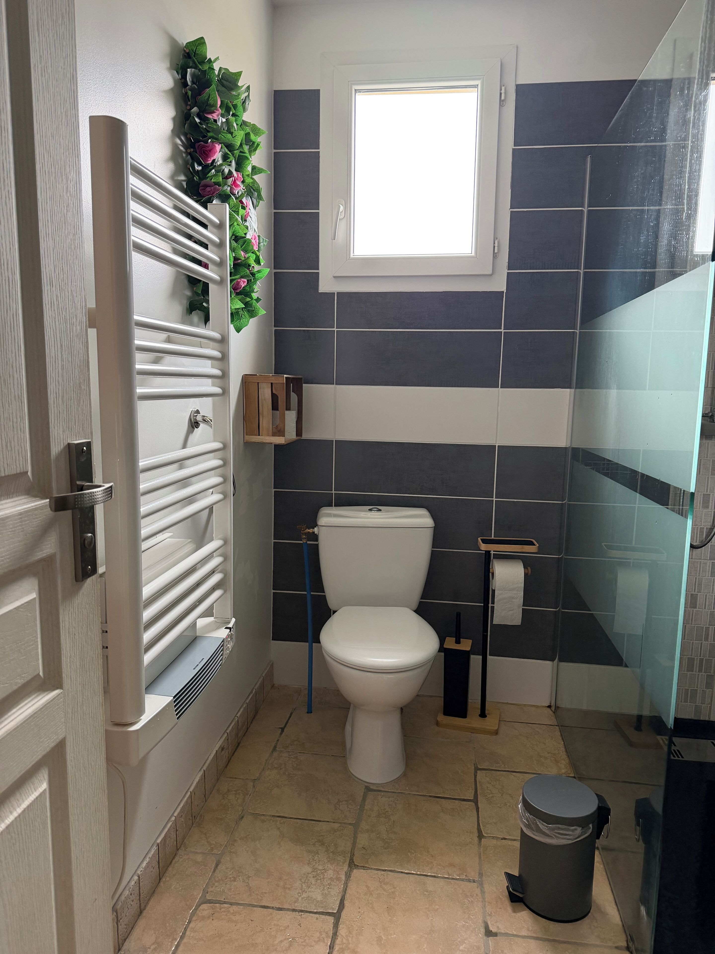 Une salle de bain équipée de toilettes, d’une douche et d’un porte-serviettes.