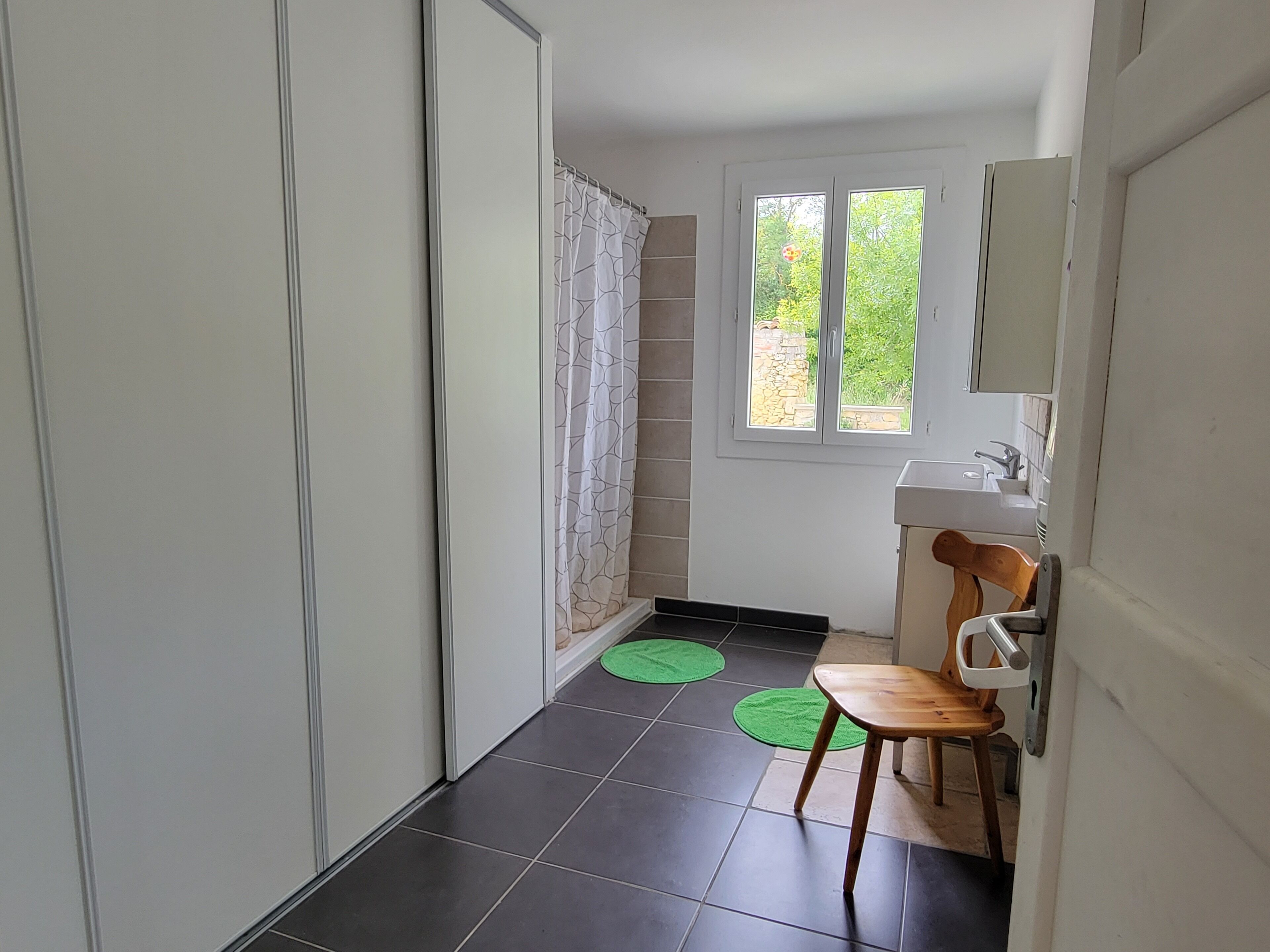 A bathroom with a sink, mirror, and a window.