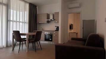 Una cucina moderna con zona pranzo, che comprende un tavolo, sedie e un forno integrato.