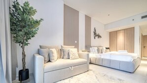 Une chambre moderne avec un canapé, un lit et une grande plante.