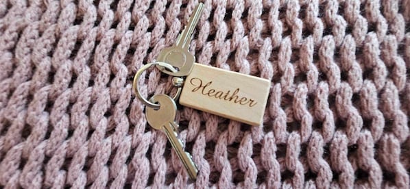A keychain with a wooden tag labeled "Heather" on a knitted fabric background. - Halmer Grange (Whitby)