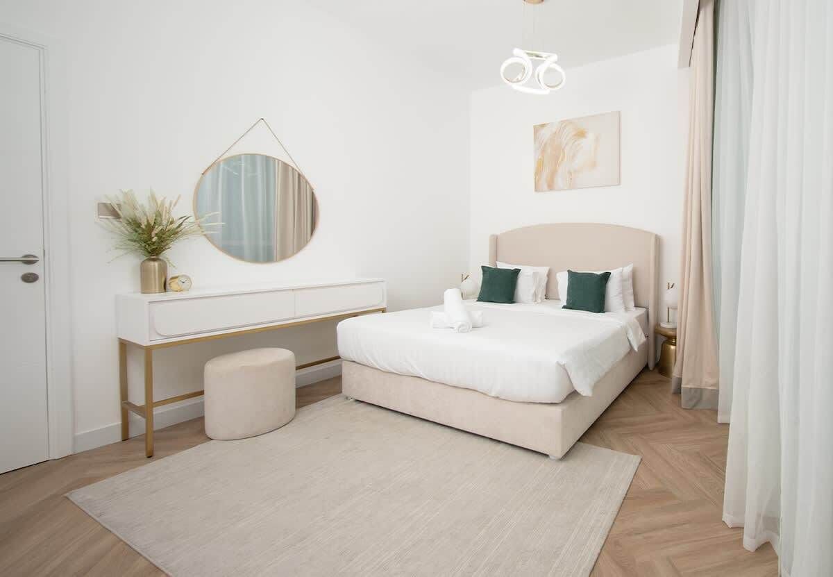 A bedroom with a bed, bedside table, mirror, and a wall-mounted bicycle light.