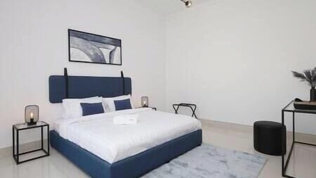 Une chambre à coucher moderne avec un lit, des tables de chevet et une commode.