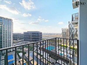Un edificio alto con vista su una piscina e sul paesaggio urbano circostante.